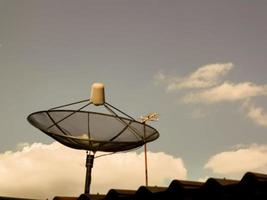 antena parabólica de tv no telhado da casa à noite foto