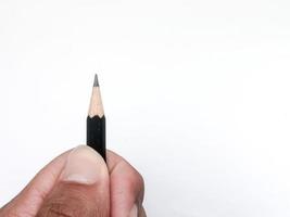 mão segurando um lápis preto pronto para escrever algo no papel foto
