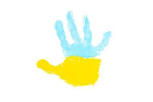 tintas amarelas e azuis da palma da mão de uma criança. conceito de símbolos de bandeira ucraniana foto
