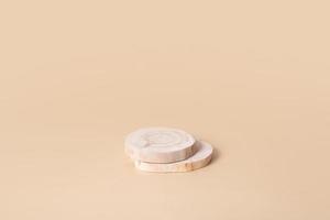 pódio ou pedestal de madeira para cosméticos, perfumes ou joias. monocromático bege neutro em estilo rústico mock up, em branco. foto