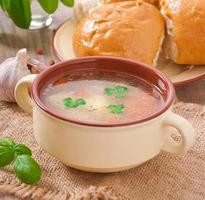 sopa de galinha na tigela de cerâmica marrom foto