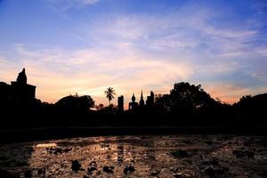 capela principal em wat maha que ao pôr do sol, parque histórico de shukhothai, tailândia foto