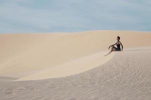 jovem mulher bonita nas dunas de areia branca como um goddes foto