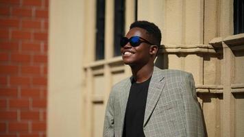 homem afro-americano se divertindo andando no centro da cidade - cara jovem feliz aproveitando o tempo um pôr do sol ao ar livre - estilo de vida da geração milenar e conceito de atitude positiva das pessoas foto