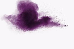 explosão de pó roxo abstrato sobre fundo branco, congele o movimento de salpicos de poeira roxa. foto