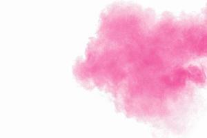 explosão de pó rosa abstrato sobre fundo branco. congelar o movimento de poeira rosa salpicada. foto