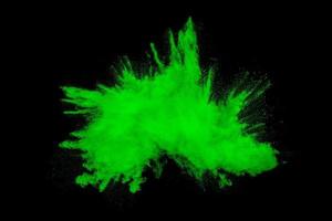 explosão de partículas de poeira laranja verde sobre fundo preto. respingo de poeira em pó de cor. foto