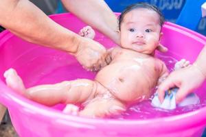 mãe asiática chuveiro bebê para limpar sujeira dar criança no recipiente de banho para limpeza estilo de vida família entre mãe e filho usado para produtos de creme para chá de bebê xampus loções e produtos para cuidados com o bebê foto