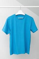 t-shirt pendurada no cabideiro. gola redonda na cor azul. modelo, simular foto