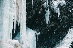 cachoeira de inverno com água congelada e neve foto
