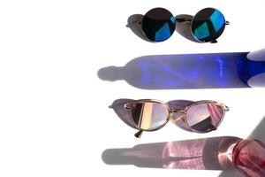 óculos de sol azuis e rosa com reflexos de garrafa de vidro foto