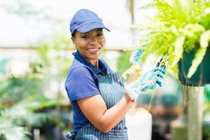 jardineiro feminino americano africano, podando uma planta foto