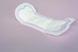 proteção de higiene da mulher. absorventes higiênicos na vista superior de fundo roxo. foto