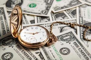 relógio de ouro e notas de dólar foto