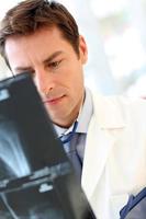médico olhando radiografia na mesa