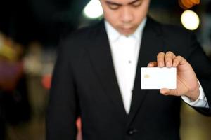 homem segurando cartão de visita em branco ou cartão de crédito branco foto