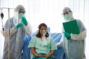 paciente asiática se sentindo feliz se recuperando da infecção pelo vírus covid-19 ou corona. equipes médicas e pacientes estão no controle de doenças ou na sala de quarentena. foto