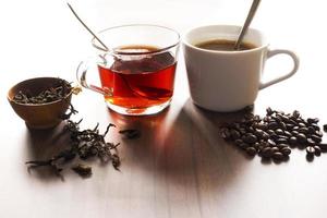 café e chá com grãos de café e folhas de chá no piso de madeira. foto