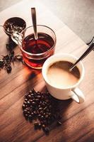 café e chá com grãos de café e folhas de chá no piso de madeira. foto