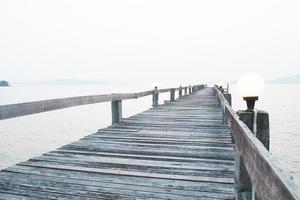 uma passarela de madeira que se estende até o mar. conceito de viagem de férias foto