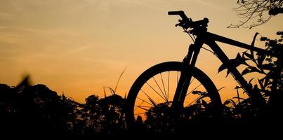 silhueta de uma bicicleta de montanha à noite. ideias de fitness e aventura foto