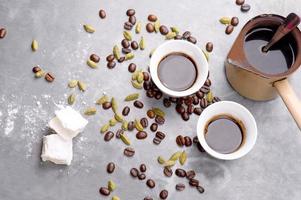café turco com grãos de café e cardamomo espalhados foto
