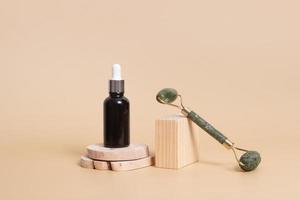 frasco conta-gotas com óleo cosmético e massageador facial em pódios de madeira. conceito de cuidados com o rosto em estilo rústico