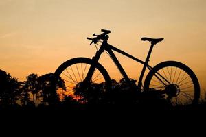 silhueta de uma bicicleta de montanha à noite. ideias de fitness e aventura foto