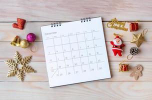 calendário de dezembro e decoração de natal - papai noel e presente na mesa de madeira. natal e feliz ano novo conceito foto