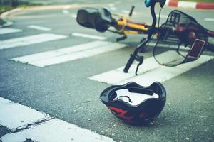 capacete e bicicleta na estrada em uma passagem para pedestres, após acidente foto