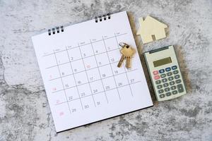 calendário e casa na mesa. dia de compra ou venda de uma casa ou pagamento de aluguel ou empréstimo. foto