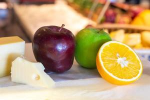 diferentes tipos de queijo com frutas frescas na mesa foto