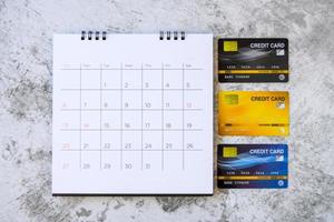 calendário com dias e cartões de crédito na mesa. conceito de compras foto