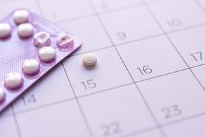 pílula anticoncepcional com data de fundo de calendário, cuidados de saúde e conceito de medicina