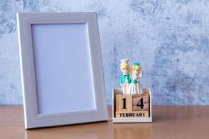 porta-retrato e casal de noivos em miniatura na mesa. Dia dos namorados foto