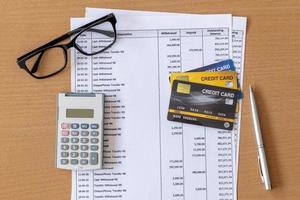 cartões de crédito e calculadora no extrato bancário em uma mesa de madeira foto
