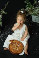 menina comemora seu primeiro aniversário. garota comendo seu primeiro bolo. foto