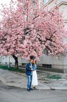casal apaixonado em um pomar de macieiras florescendo deitado no cobertor