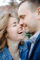 rostos de casal jovem amoroso rindo com os olhos fechados foto