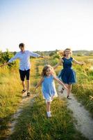 pai mãe e filha se divertem juntos na natureza. foto