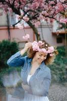 mulher bonita desfrutando de campo de margaridas, bela fêmea deitada no prado de flores, menina bonita relaxante ao ar livre, se divertindo, segurando a planta, jovem feliz e natureza verde primavera, conceito de harmonia foto