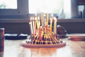 bolo de aniversário colorido com dezenove velas na mesa festa infantil em casa foto