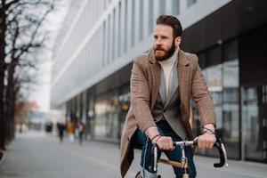 empresário jovem hipster vai trabalhar na bicicleta. conceito de transporte ecológico foto