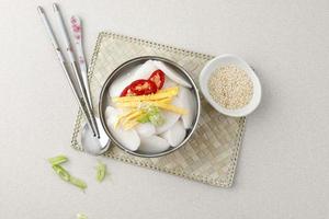 comida tradicional coreana sopa de bolo de arroz tteokguk com colheres e pauzinhos, coreia do sul foto