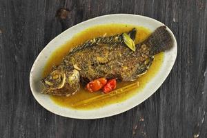 pesmol ika nila, curry amarelo de tilápia, receita popular de curry foto
