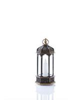 lanterna árabe ornamental com vela acesa brilhando sobre fundo branco. foto