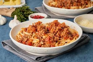 linguine de macarrão à bolonhesa com carne moída e tomate. jantar italiano para dois foto