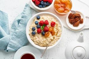 mingau de aveia com mirtilo, framboesas, geléia e nozes, vista superior. café da manhã com frutas foto