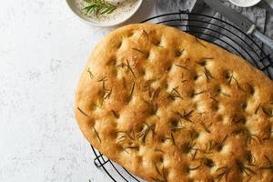 focaccia, pizza, pão italiano com alecrim e azeite na grade foto