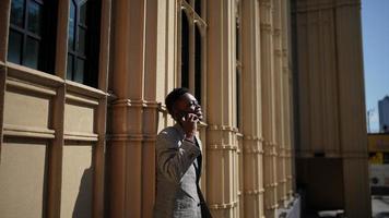 homem afro-americano se divertindo andando no centro da cidade - cara jovem feliz aproveitando o tempo um pôr do sol ao ar livre - estilo de vida da geração milenar e conceito de atitude positiva das pessoas foto